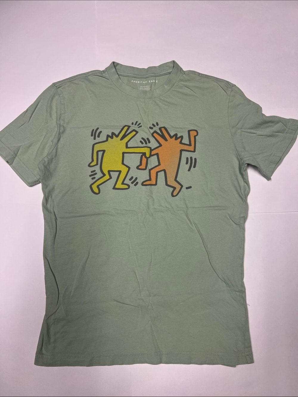 American Eagle Outfitters Sage Green Graphic Tee with Yellow & Orange Figures